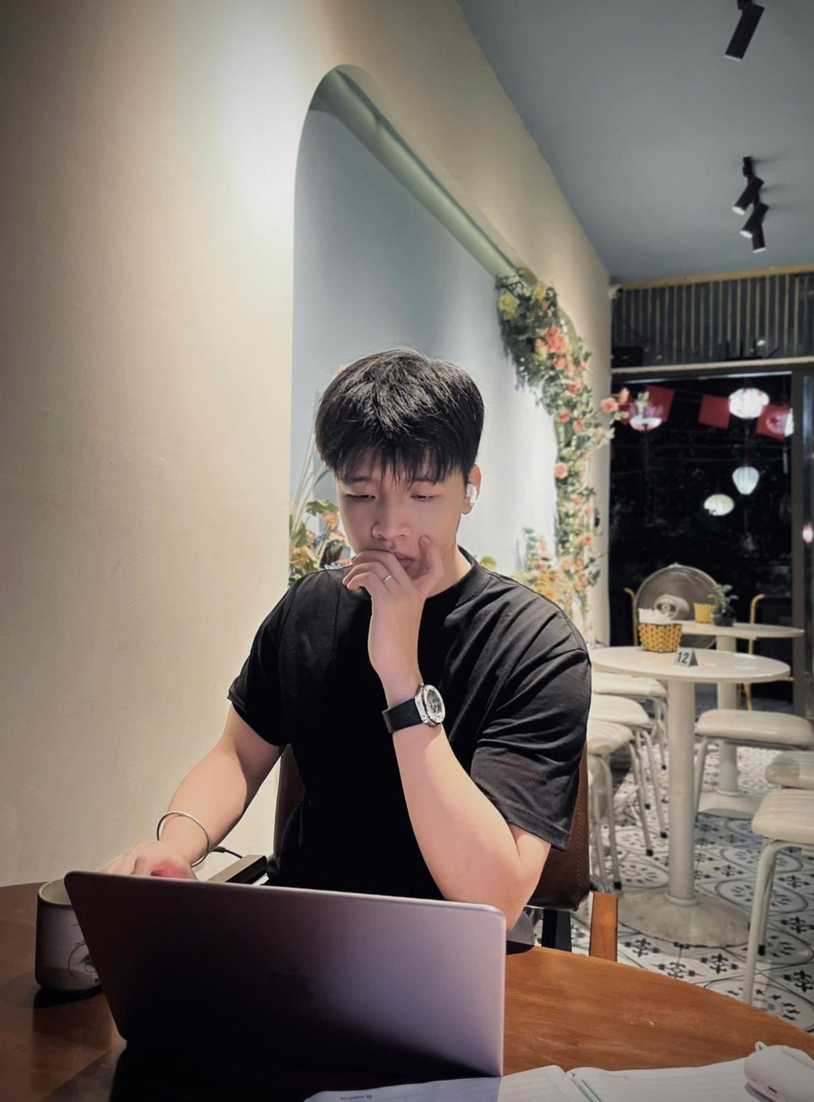 Minh làm việc với laptop ở quán cà phê